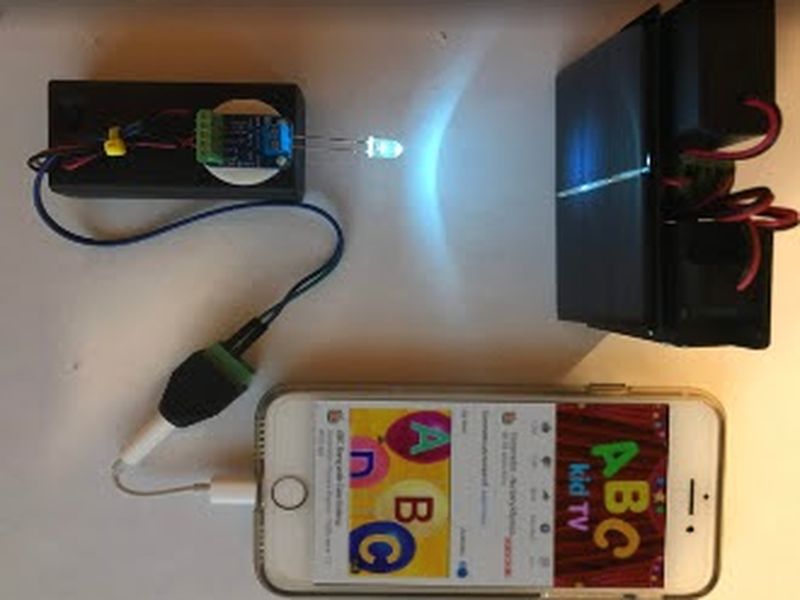 A phone streaming music through an LED transmitter to the DIY receiver